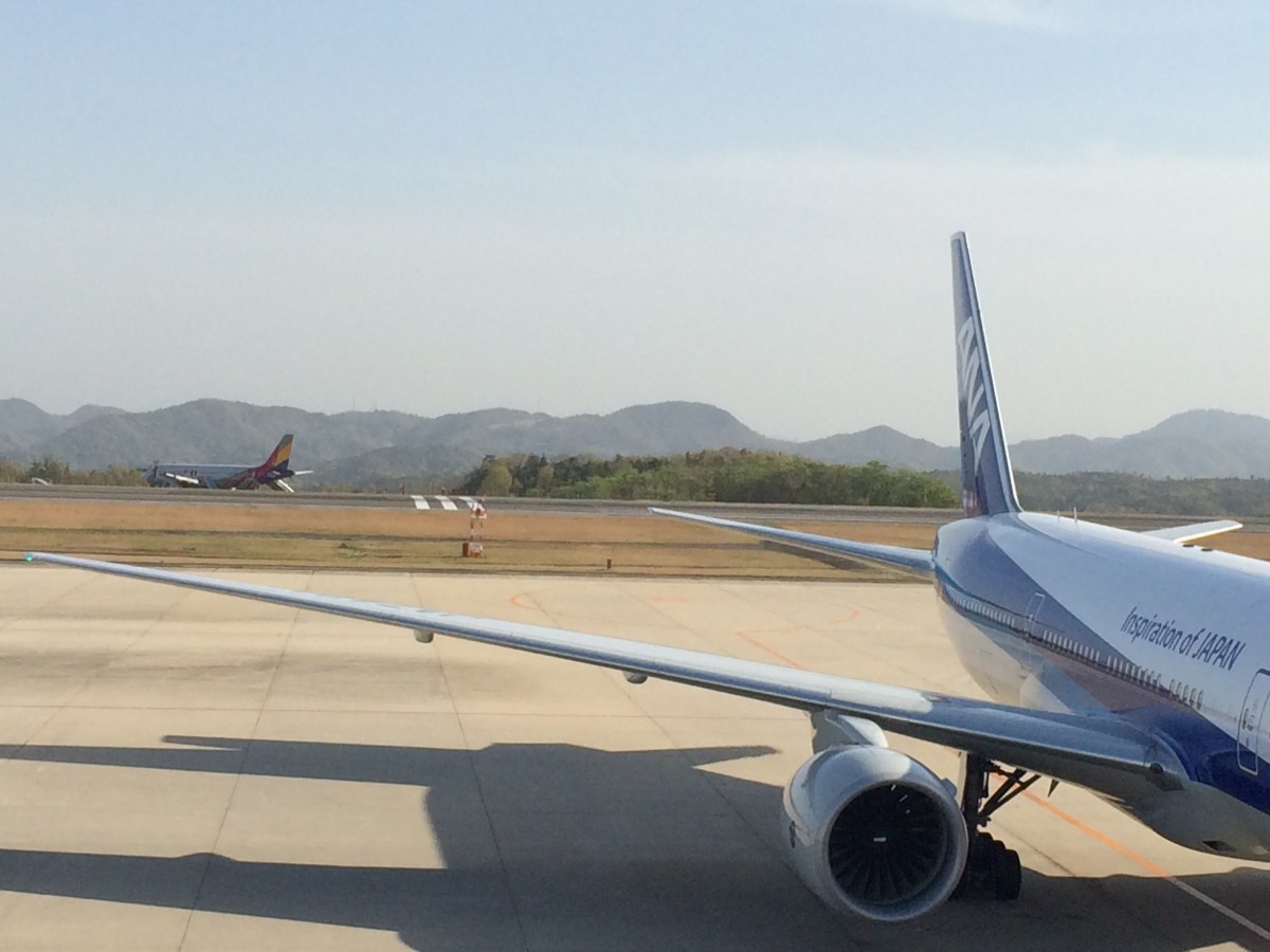 「日本一不便な主要空港」としてその名も高い広島空港。今年の4月14日には、アシアナ航空機が計器着陸装置アンテナをなぎ倒して着陸失敗事故を起こしたことで、その名を不動のものにしました。遠くに見えるのがアシアナ航空の飛行機（編集部撮影：2015年４月16日）だ。 〜 画像1