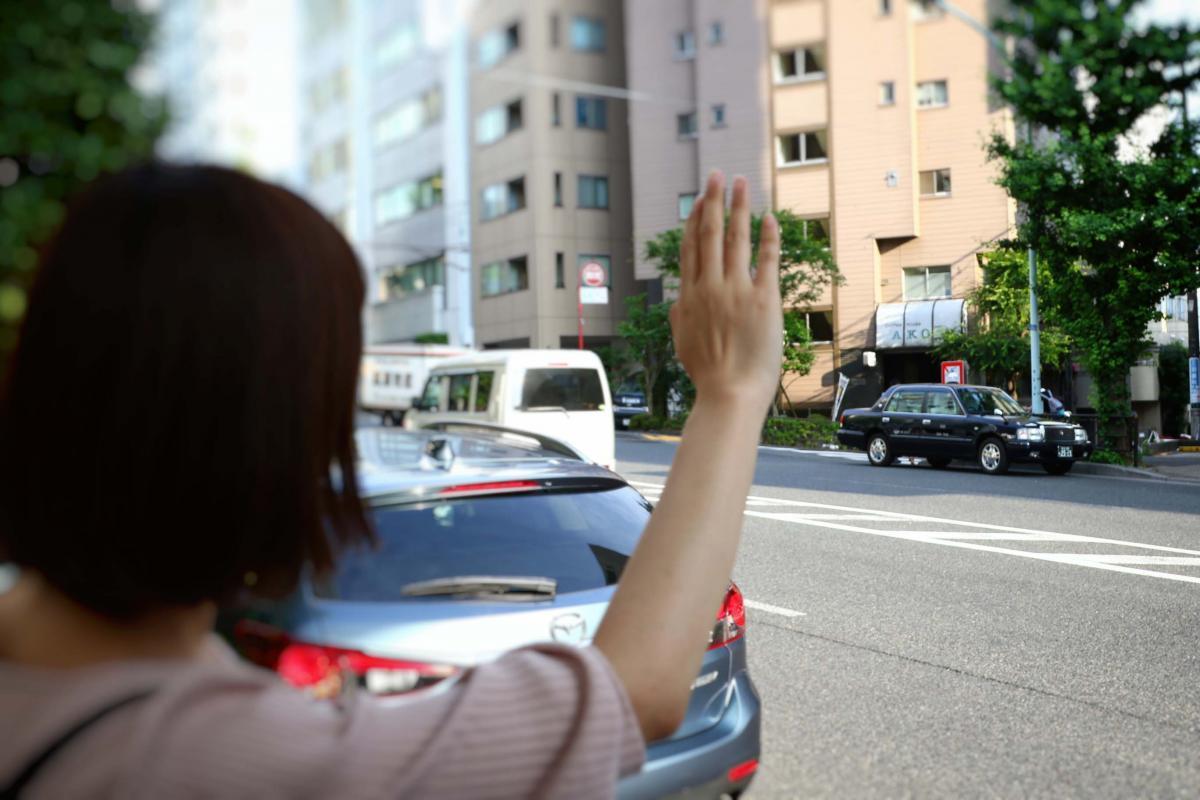 街中で手を挙げるイメージ