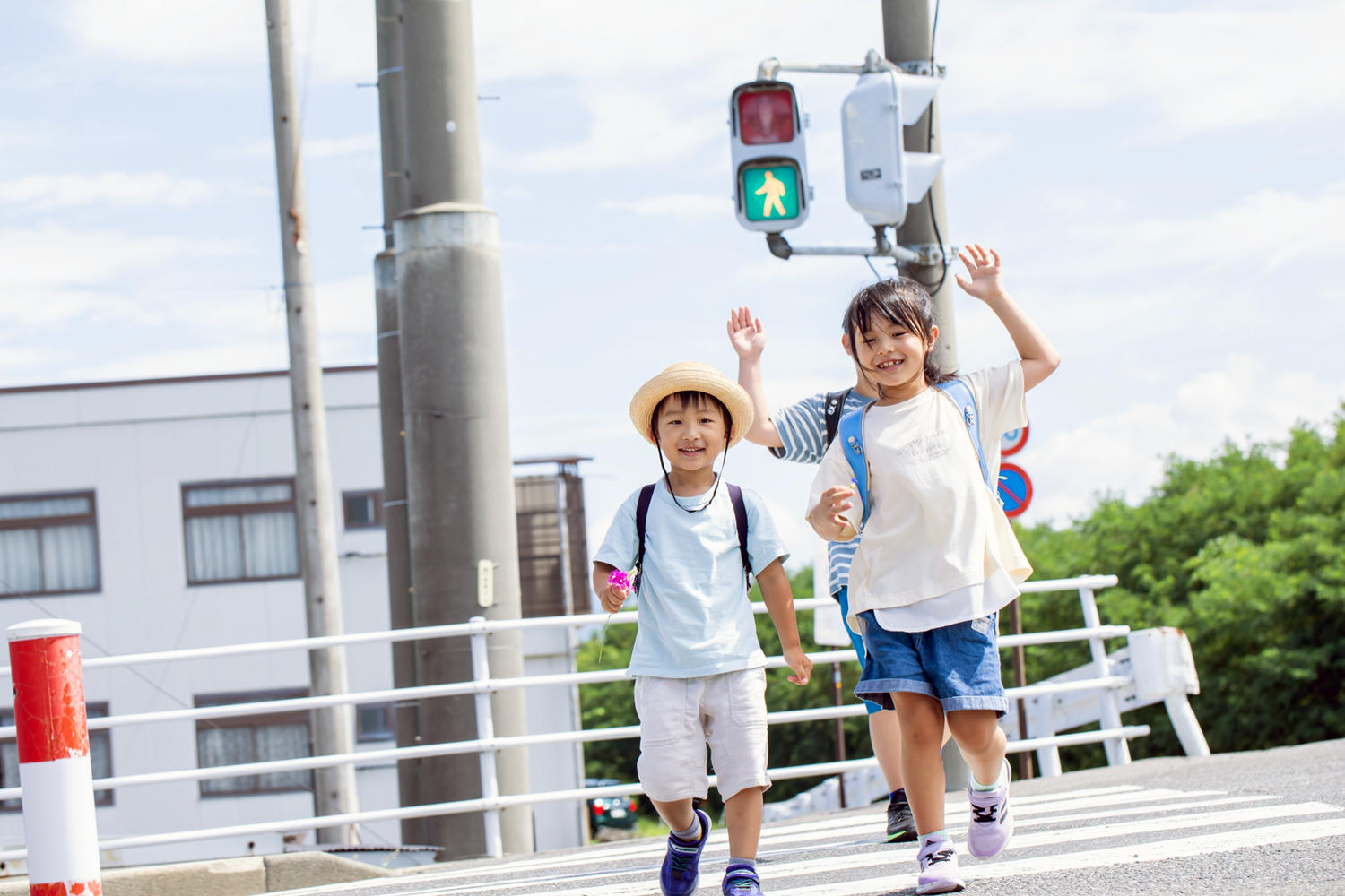 手を上げて横断歩道を渡る子ども