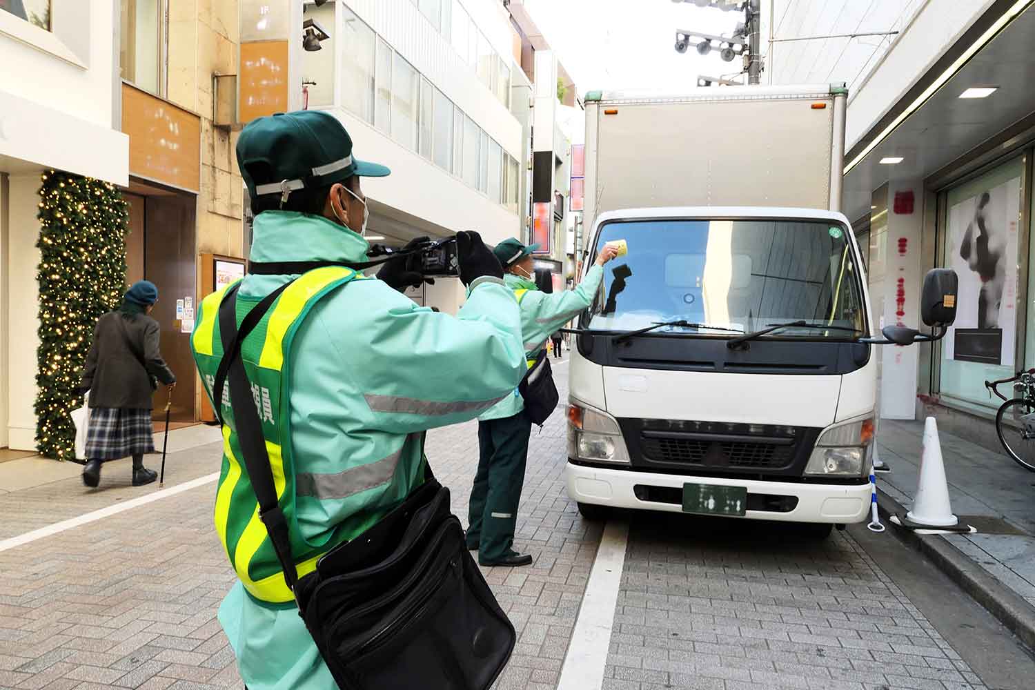 駐車違反のトラックをデジカメで撮影している写真 〜 画像3