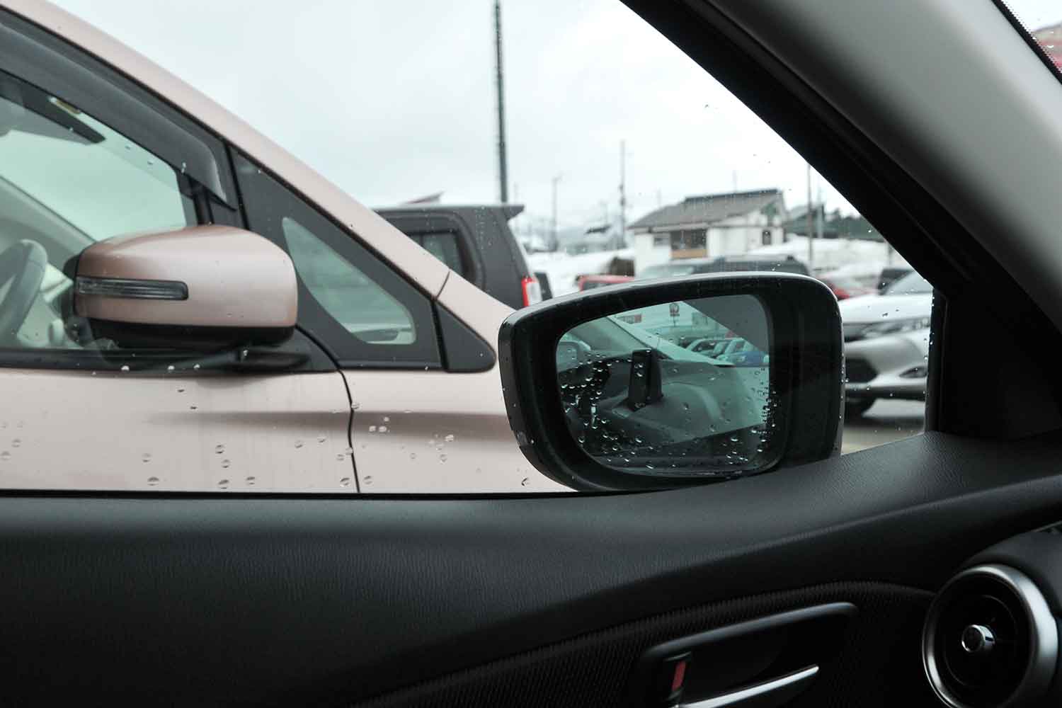 駐車場でドアミラーを畳んで駐車しているクルマ