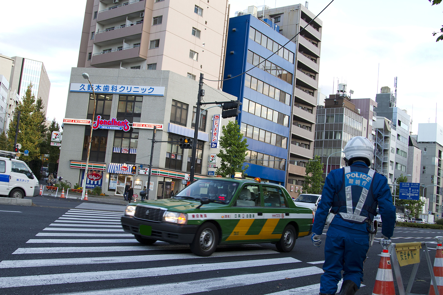 横断歩道の近くを走行するタクシー 〜 画像3