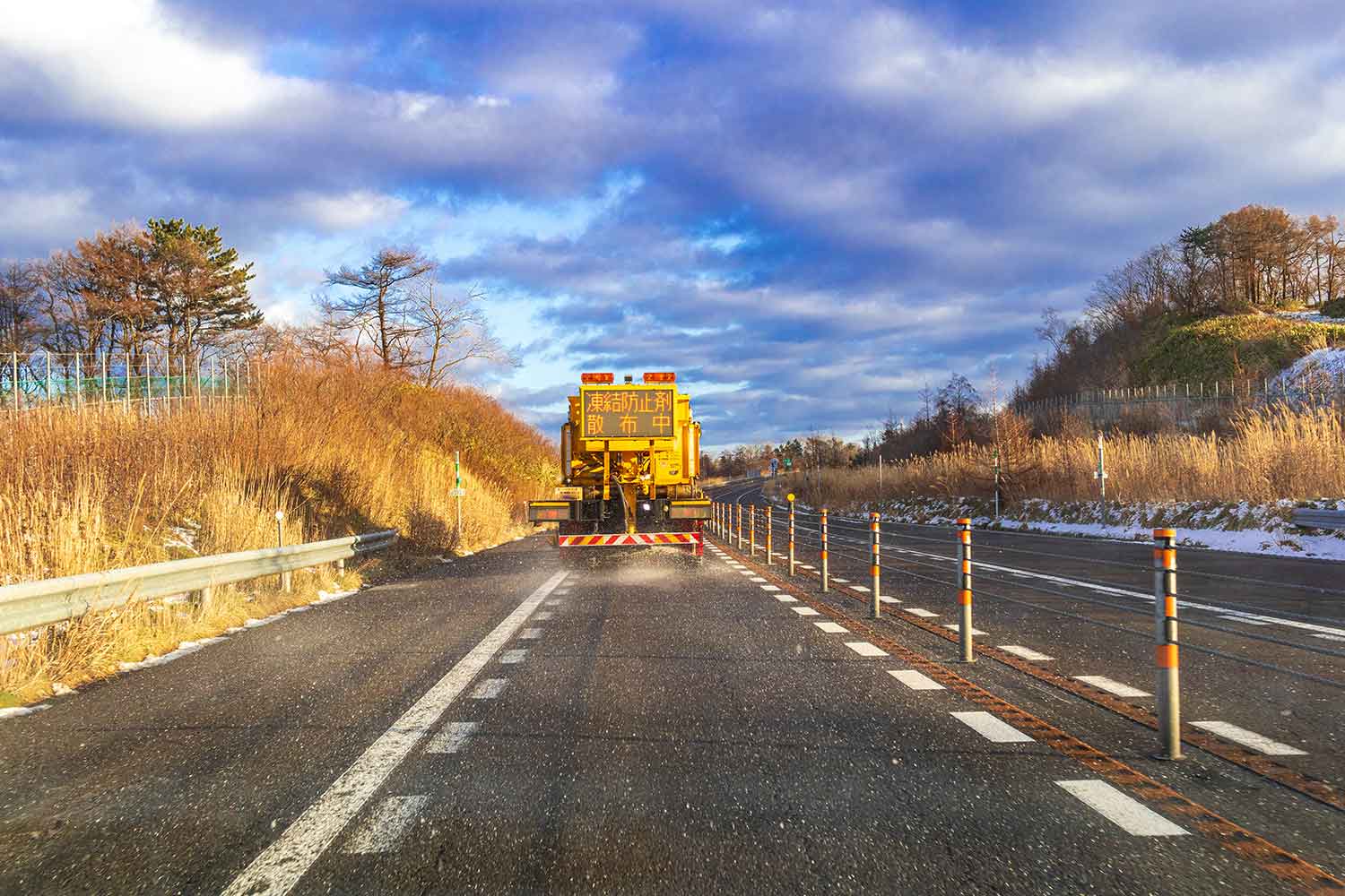 作業車が凍結防止剤を道路上に撒いている写真 〜 画像2