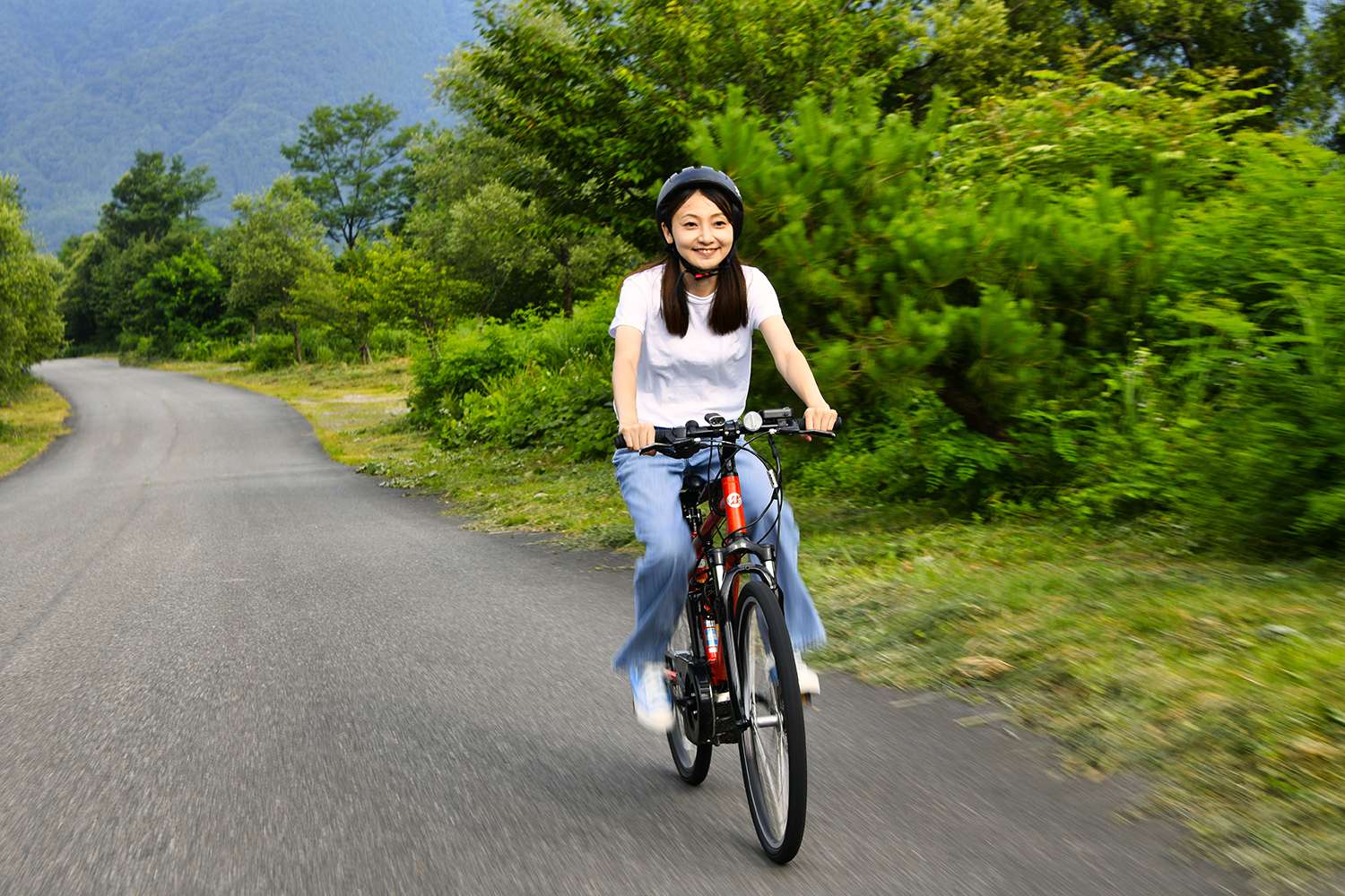 電動自転車を漕ぐWEB CARTOP編集部・乾ひかり