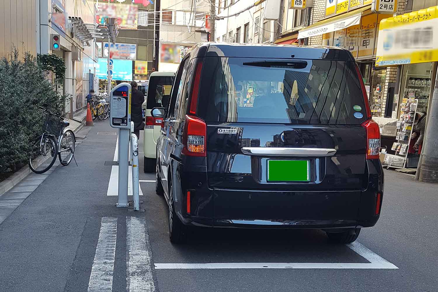 パーキング・メーターの駐車枠ギリギリに駐車しているタクシー