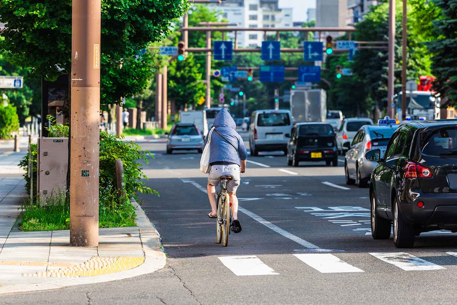 フードを被って自転車を運転しているイメージ写真 〜 画像5