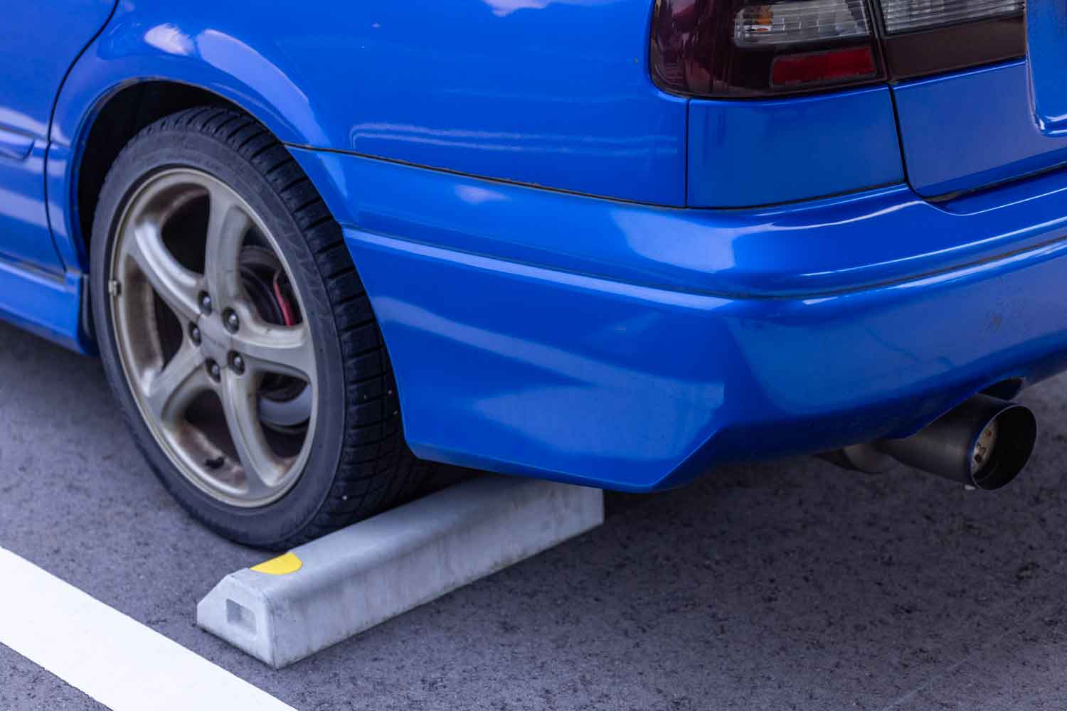 駐車場の車止めに接して駐車している写真