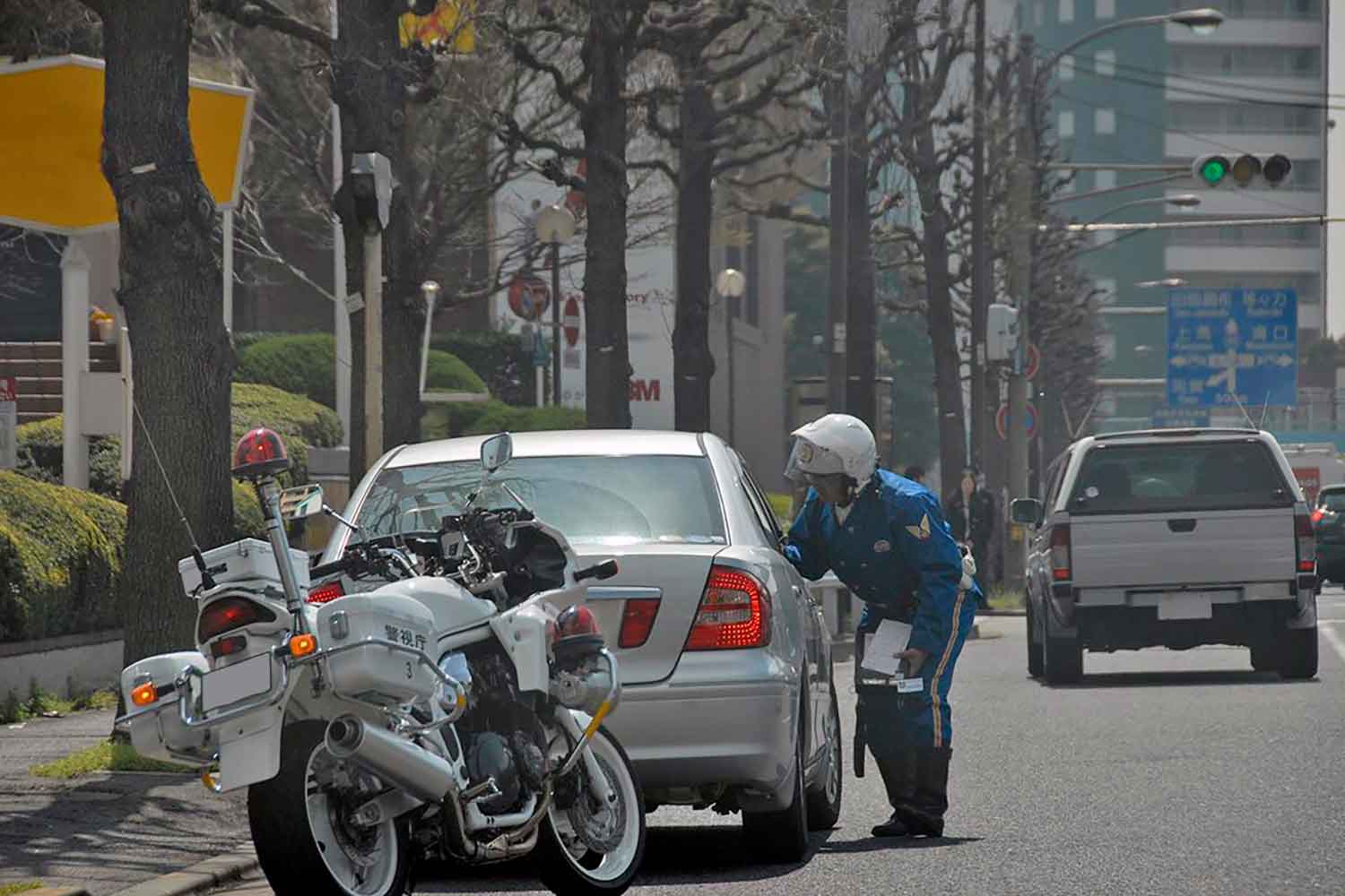 交通違反で警官がドライバーへ説明している場面 〜 画像2