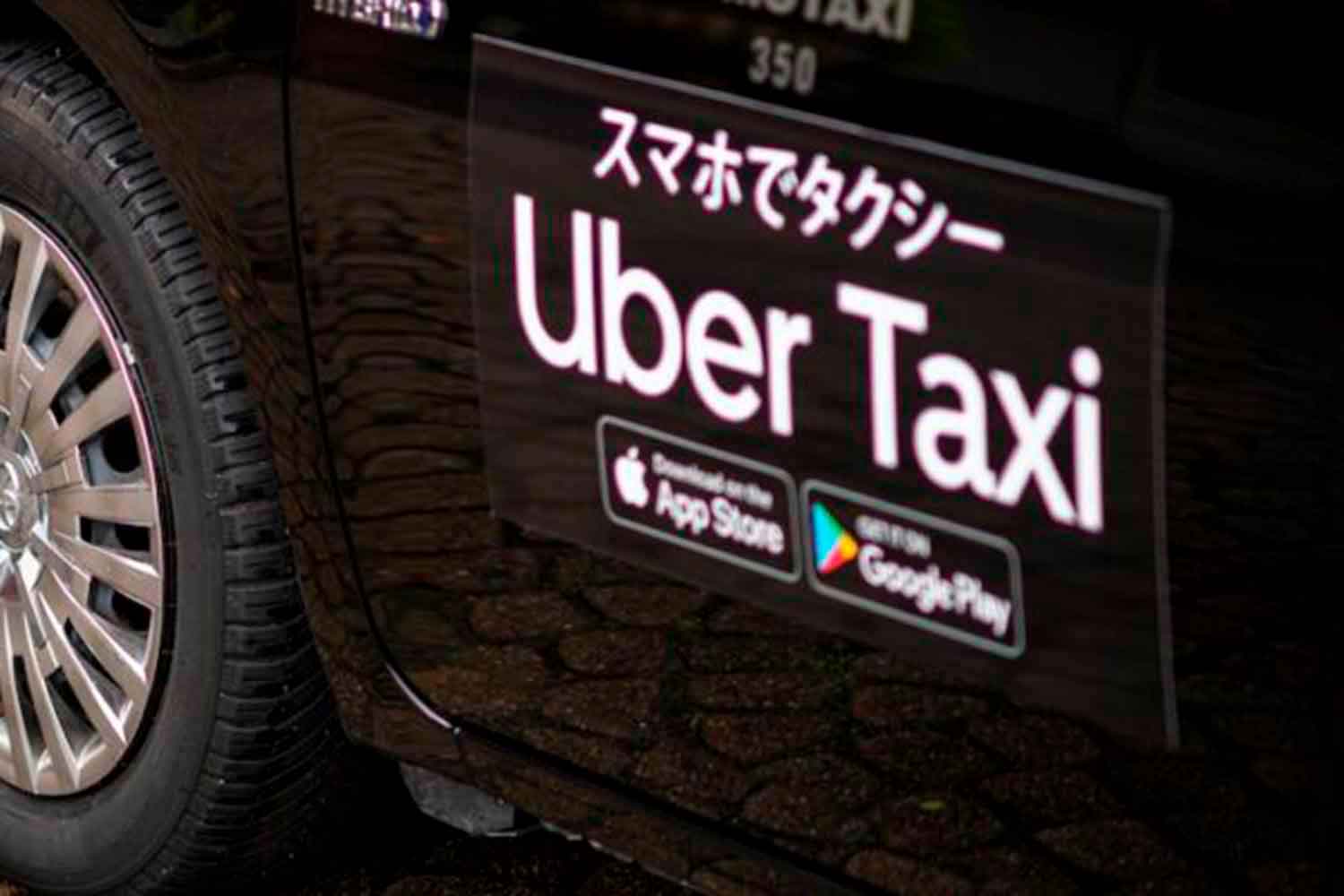 Uber Taxiのロゴステッカーが貼られたタクシー