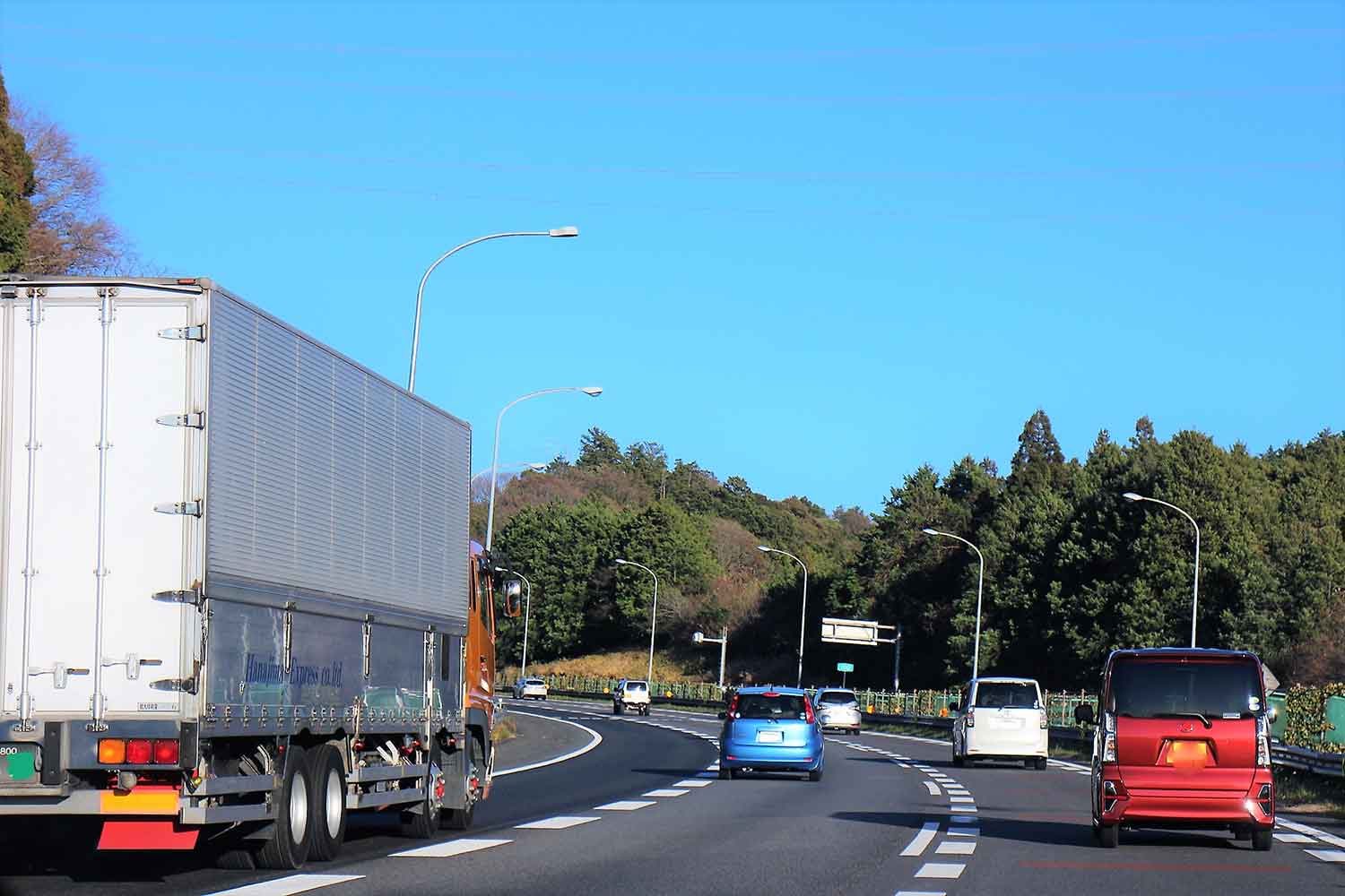 左側の車線を走行する大型トラックのイメージ写真