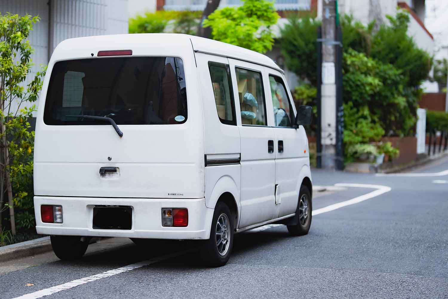 宅配の軽トラが路上駐車しているイメージ