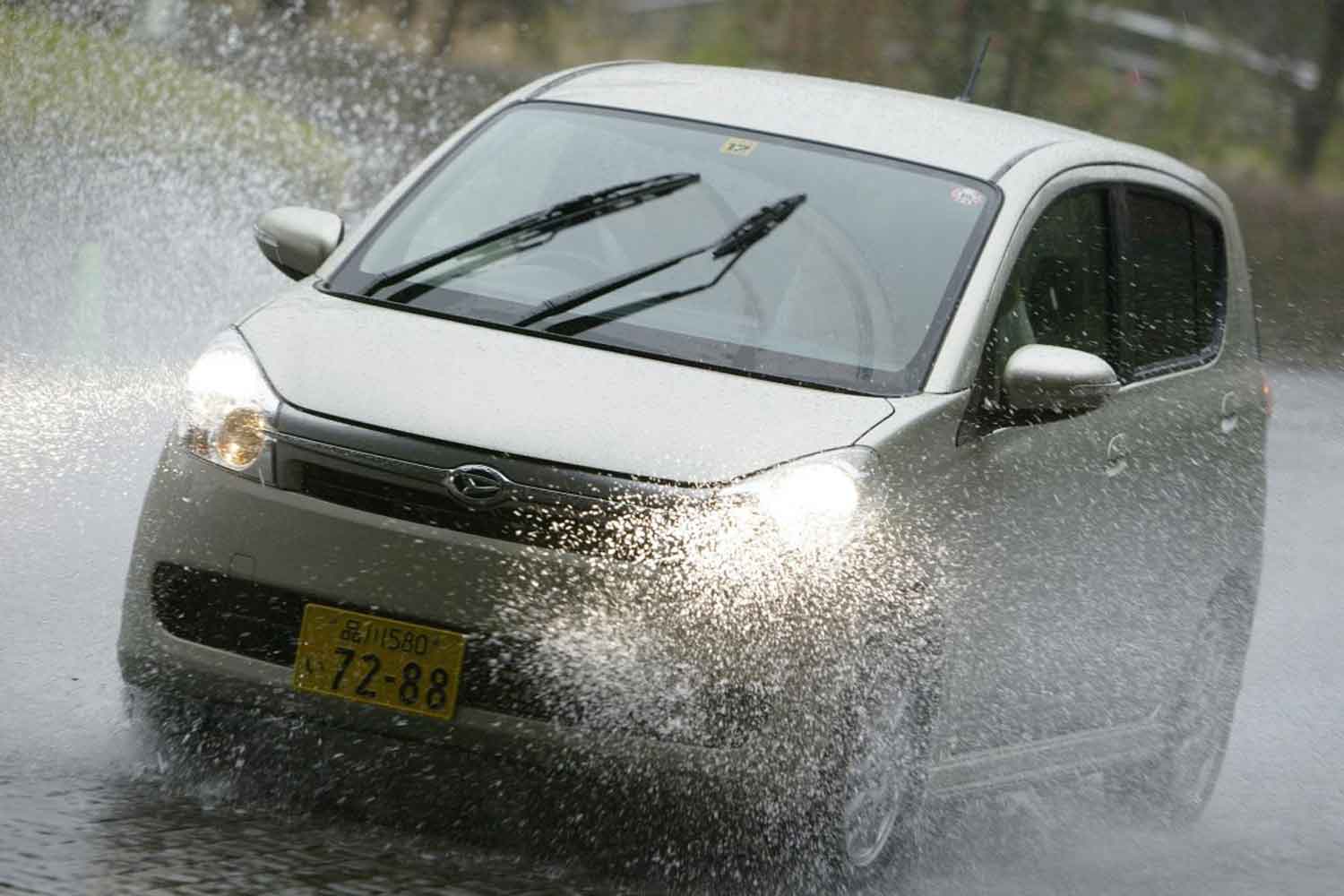 水たまりを通過する軽自動車