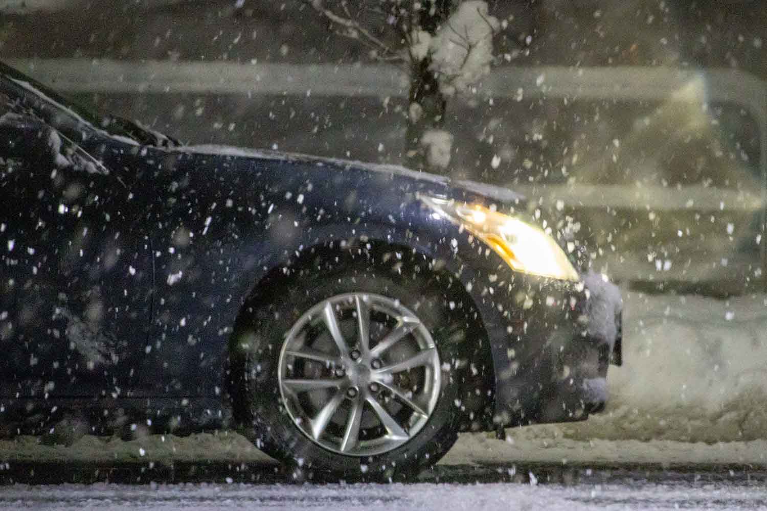 降雪地域を走るハロゲンランプのクルマ