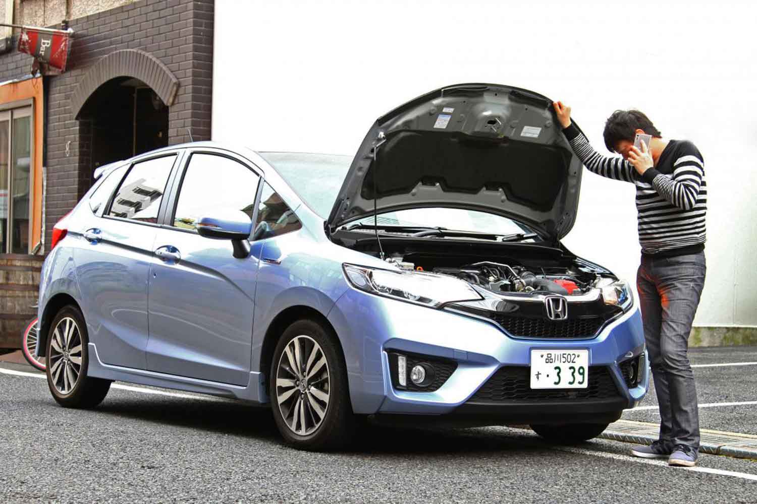 クルマの故障で路肩に停車して電話している様子