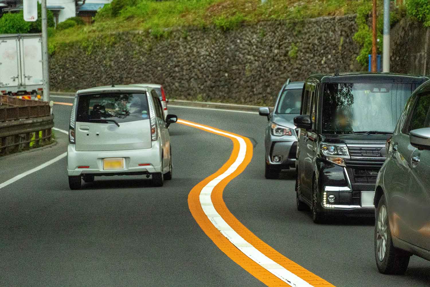 白線とオレンジの実線が引かれた道路