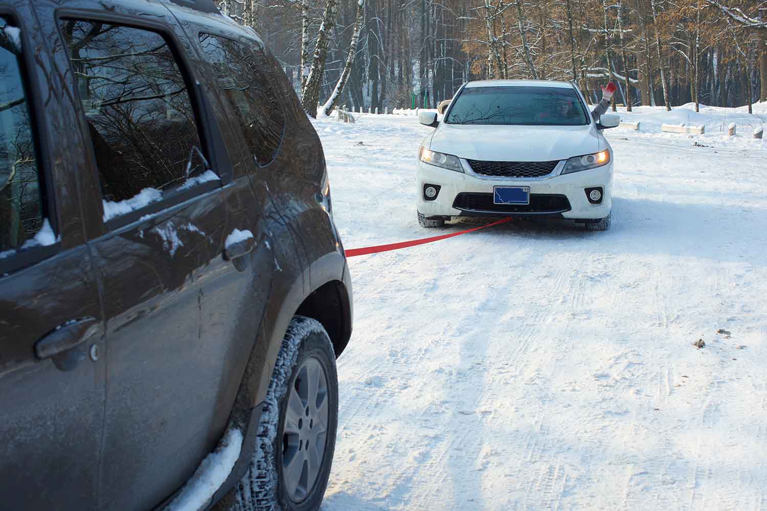 ロープで故障車をけん引する普通車のイメージ