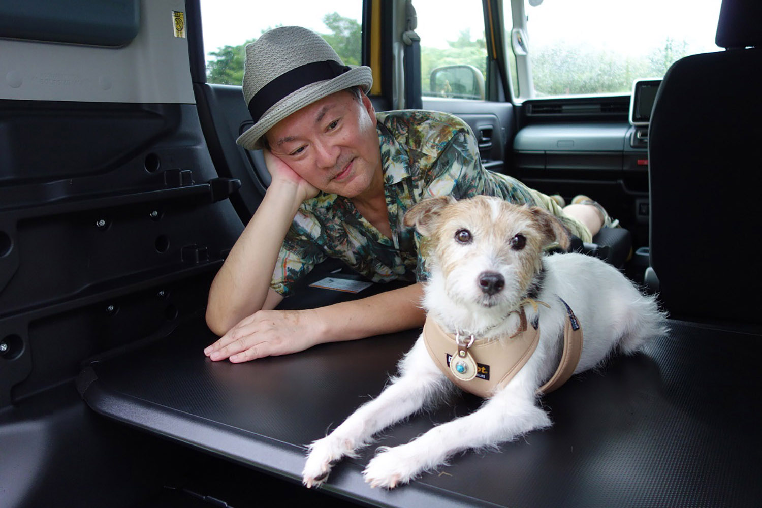 フラットにした車内で休憩する青山さんと愛犬