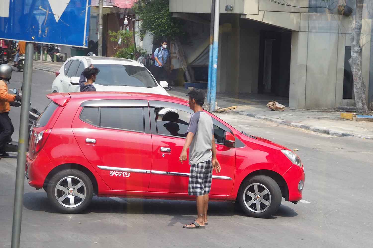 勝手な交通整理と駐車誘導で小遣い稼ぎをするインドネシアのおじさんたち 〜 画像1