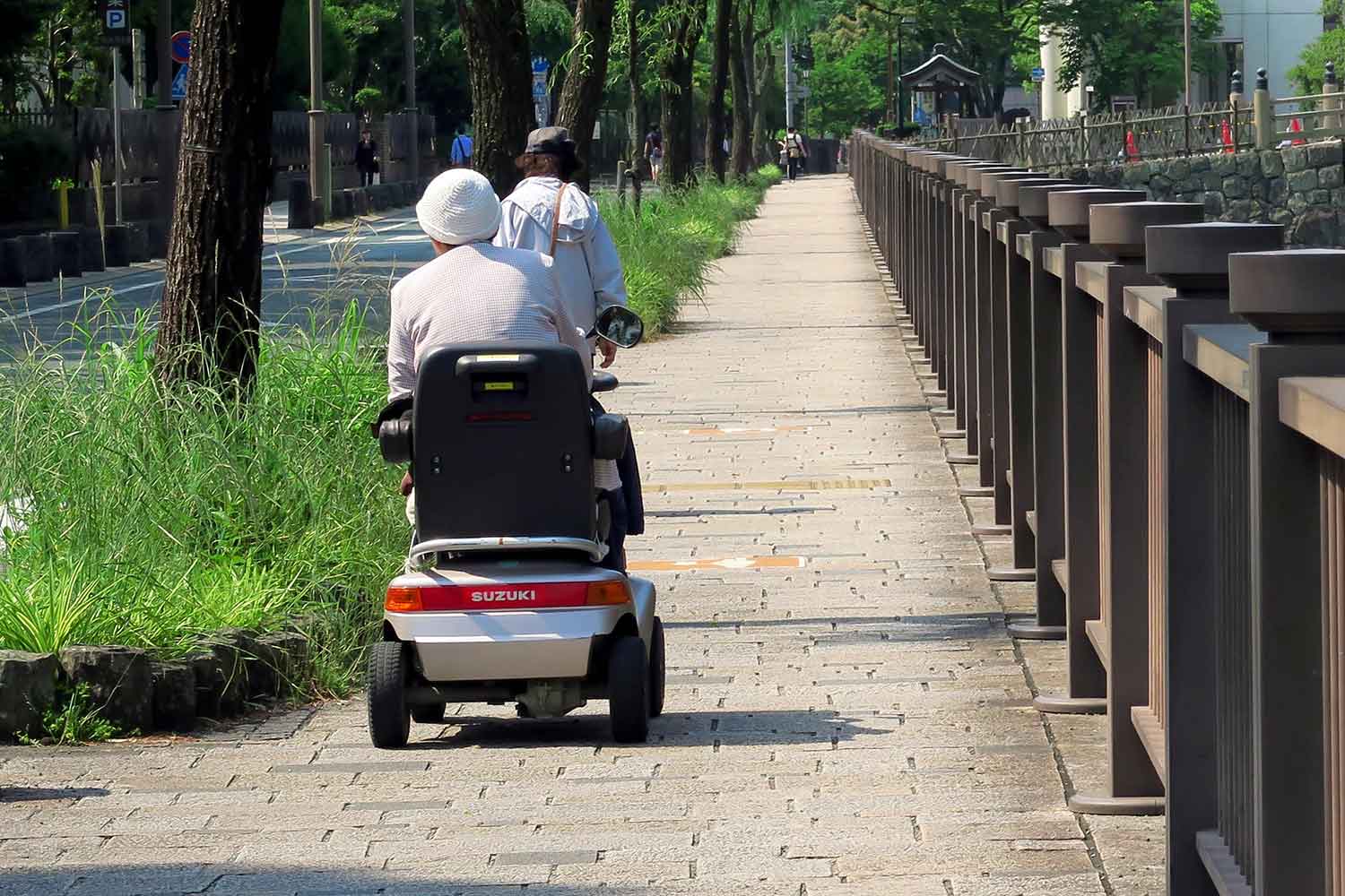 電動車いすを歩道で走らせている様子