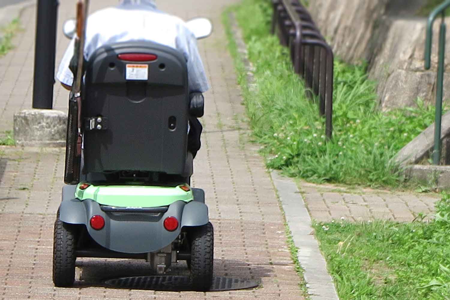 歩道を走る電動車いすの後ろ姿 〜 画像5