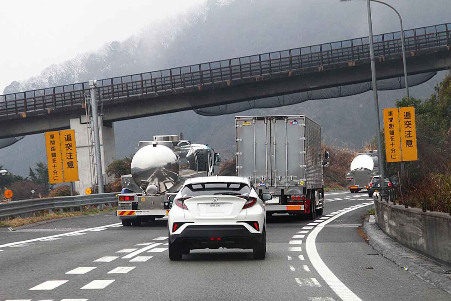 大型トラックとの車間距離が狭い乗用車の様子