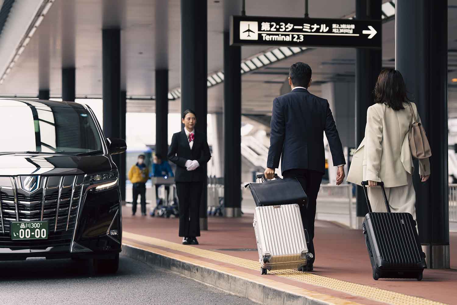 空港の車寄せにいるハイヤーと利用客