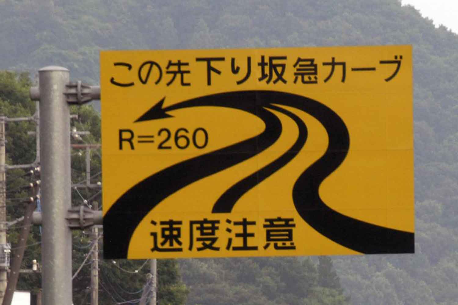 下り坂の急カーブの注意喚起の道路標識