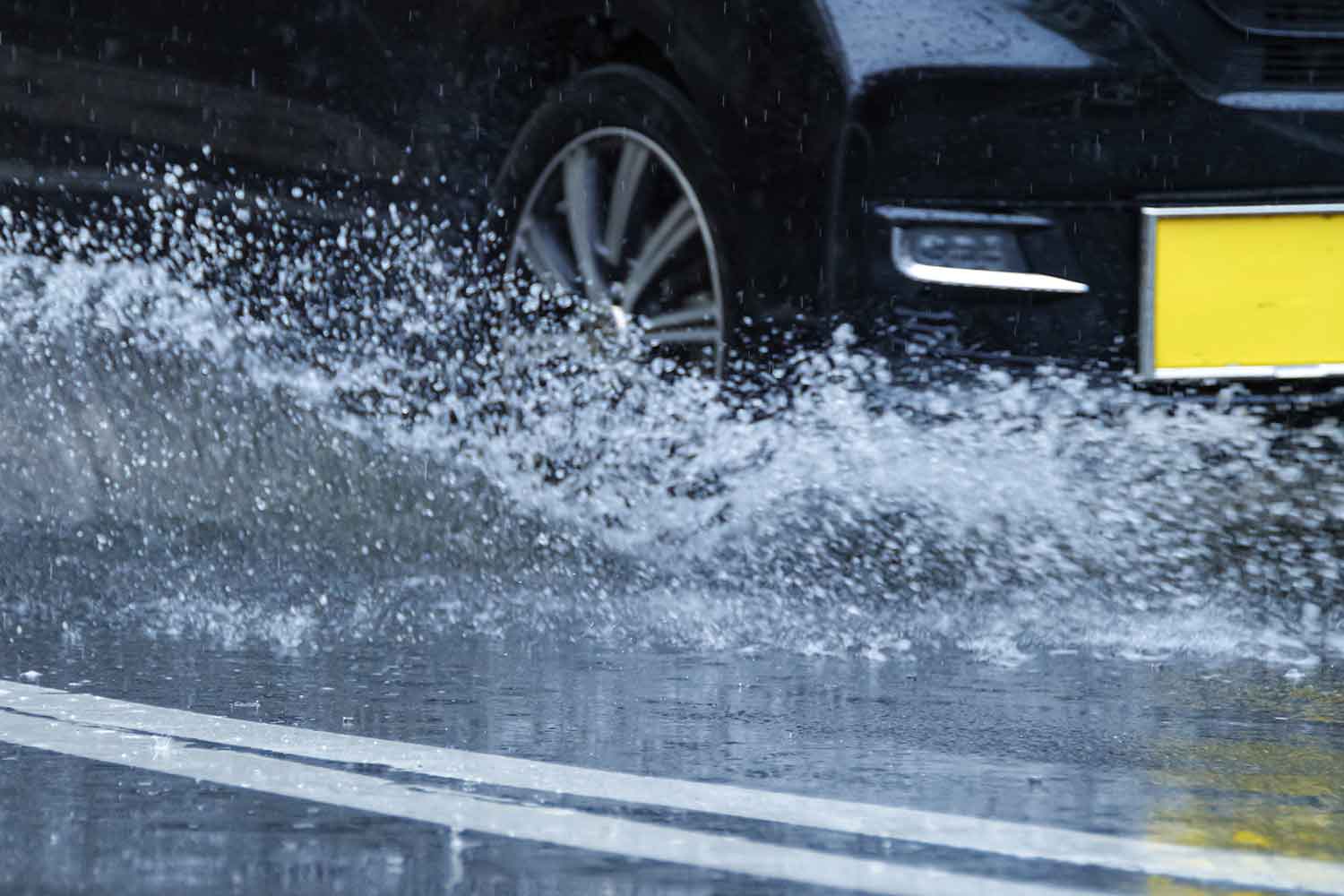 雨の日に走行している軽自動車のタイヤまわり