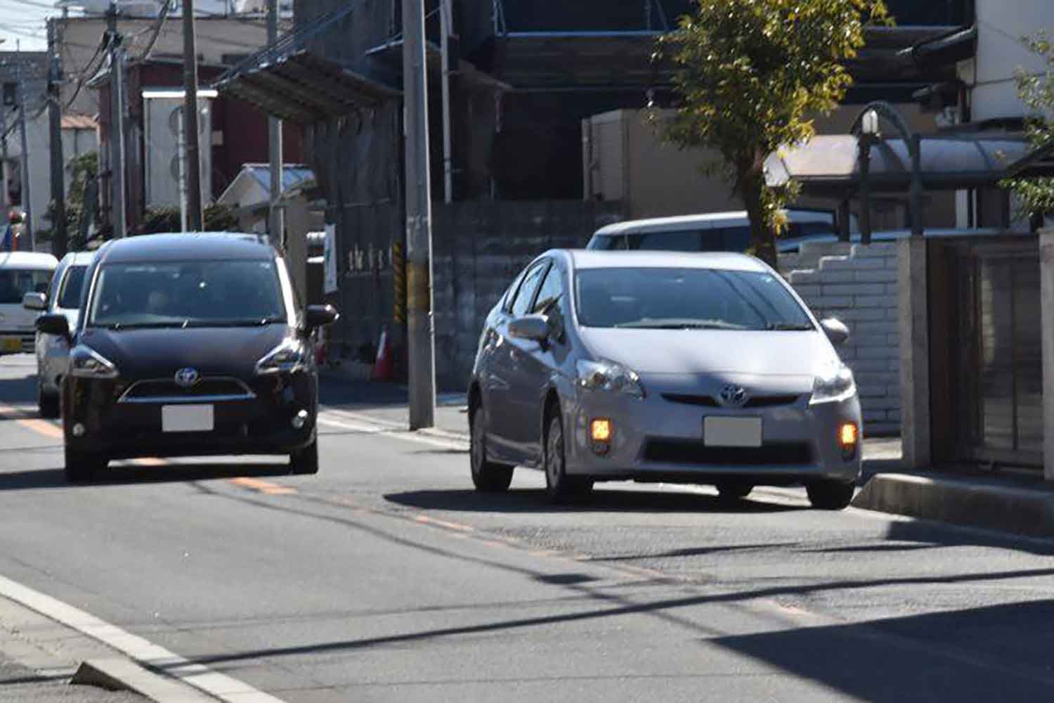 駐車車両を避けて通行しようとする車列の様子