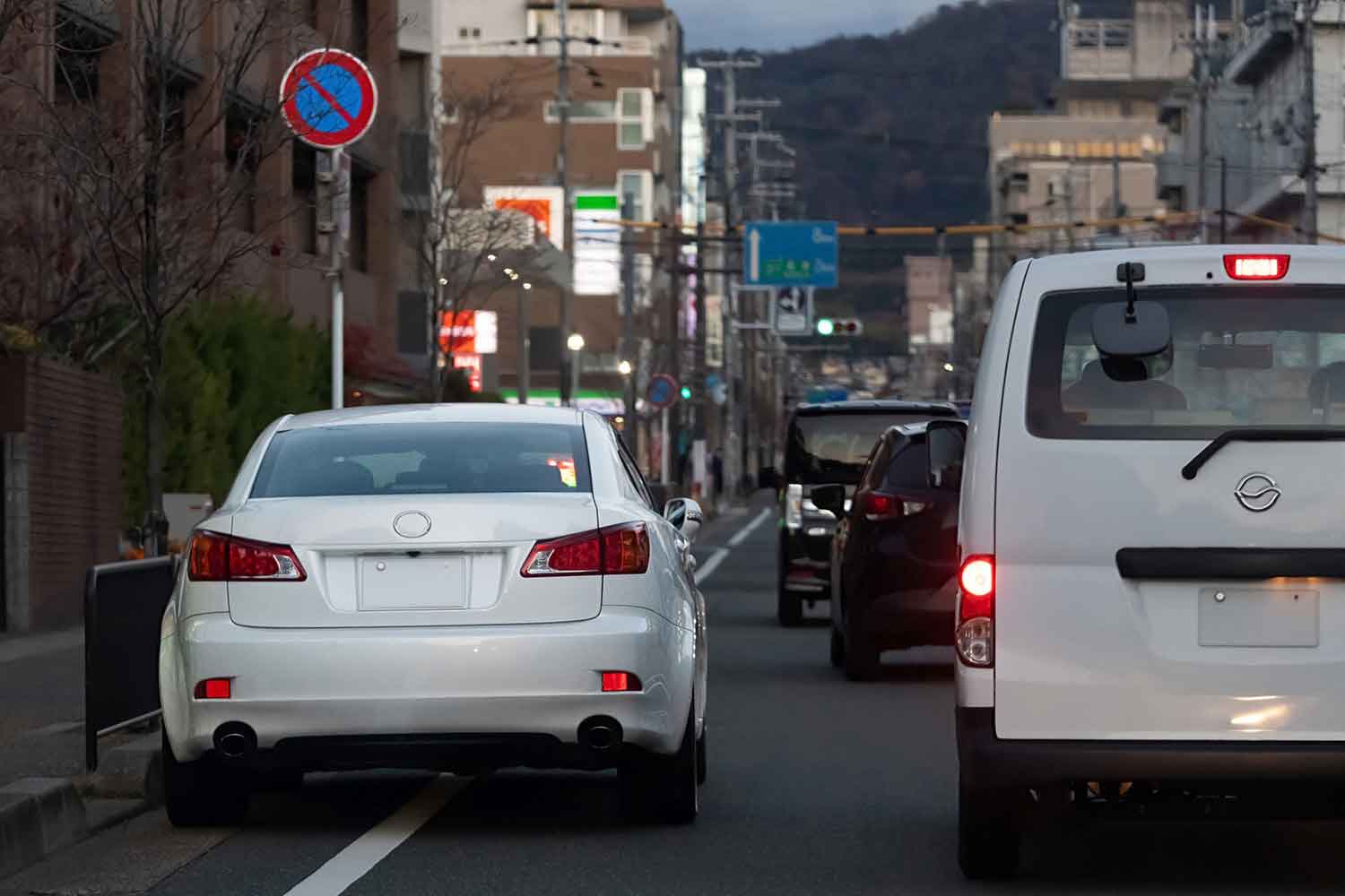 路上駐車車両を避けて通行するクルマの様子