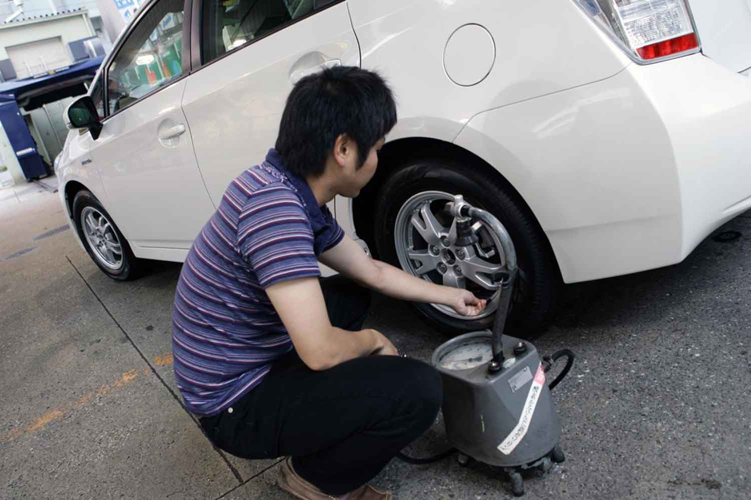 コンプレッサーでタイヤの空気圧を補充している様子