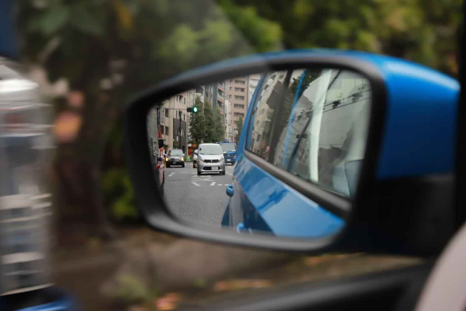 サイドミラーで後続車との距離を見ている様子