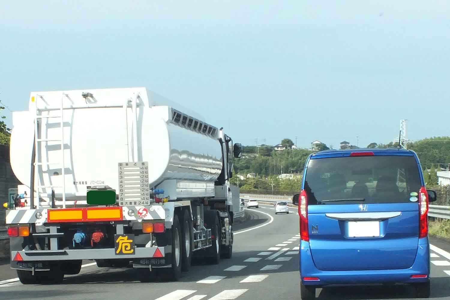 タンクローリーを追い越している軽自動車