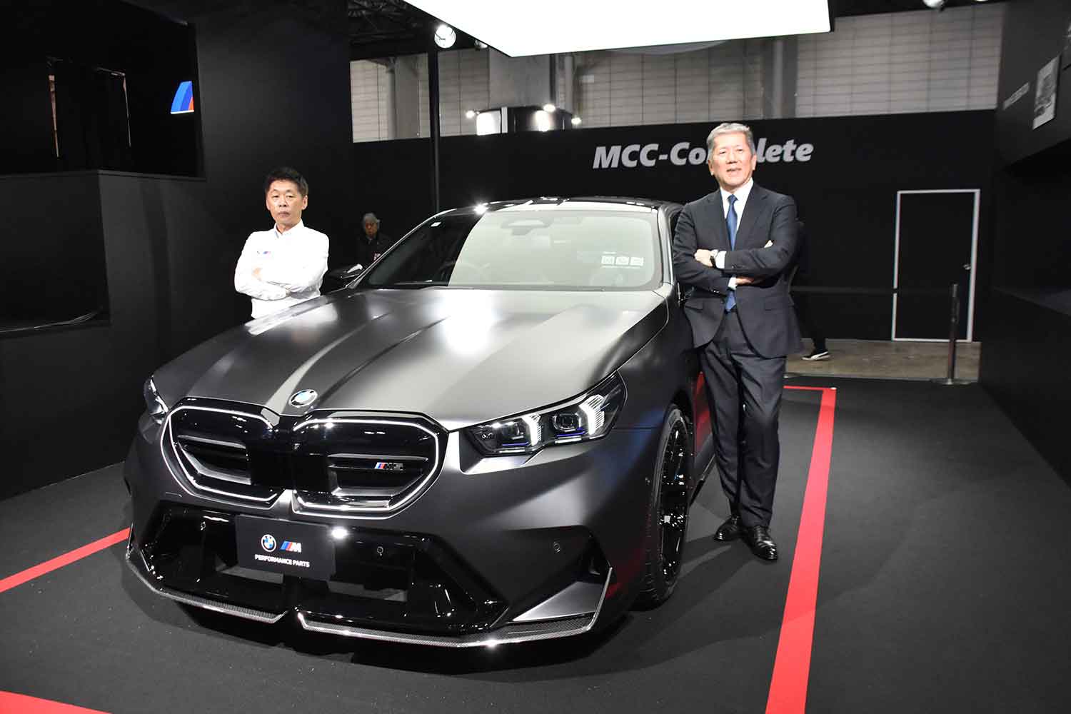 BMWブースで初公開された新型M5セダン Mパフォーマンスパーツ装着車とBMWジャパン代表取締役社長の長谷川正敏氏