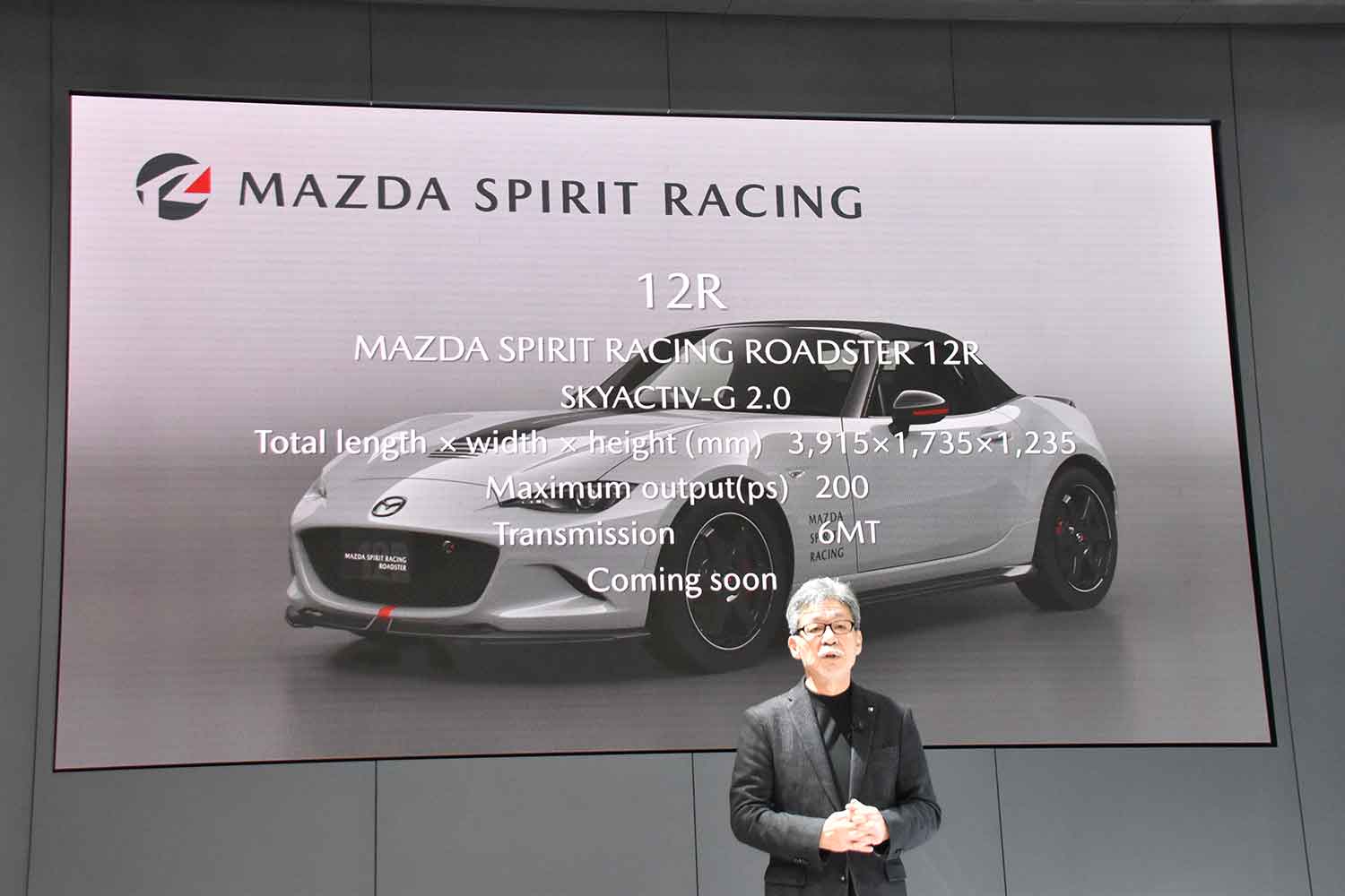 壇上に表示された「MAZDA SPIRIT RACING ROADSTER 12R」のスペックと前田育男氏 〜 画像7