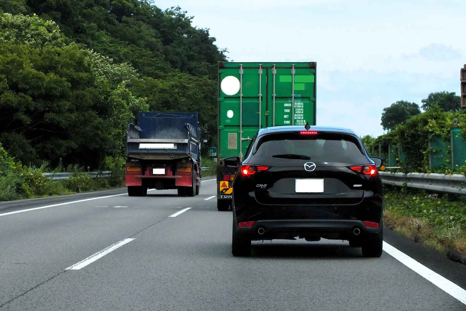 2車線に大型トラックがいるため抜かせない乗用車の様子