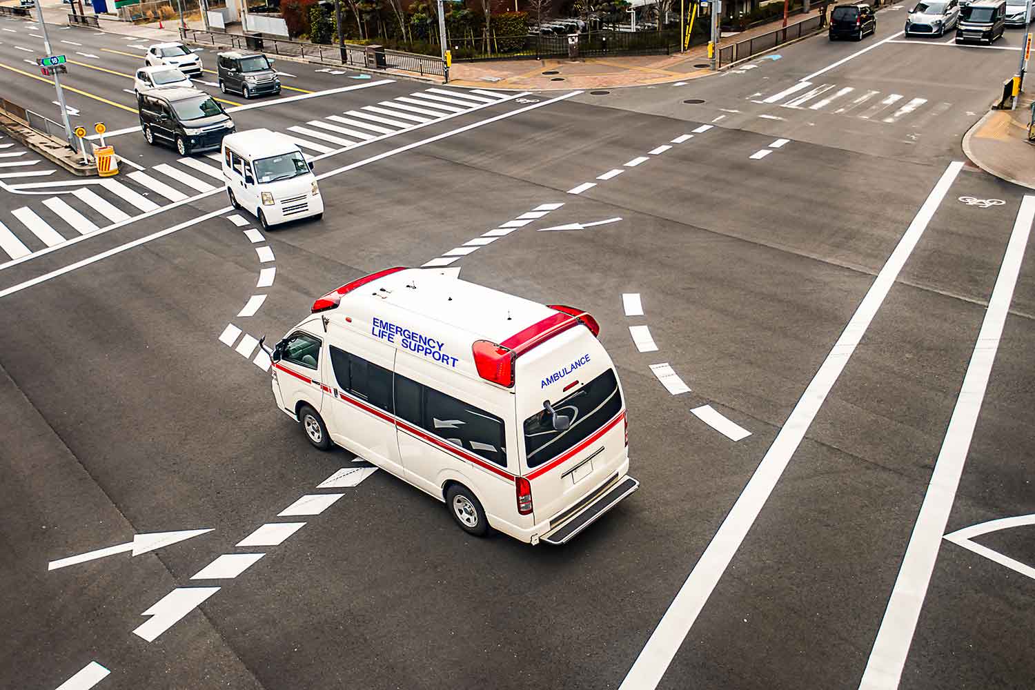 緊急走行で交差点内を通過している救急車