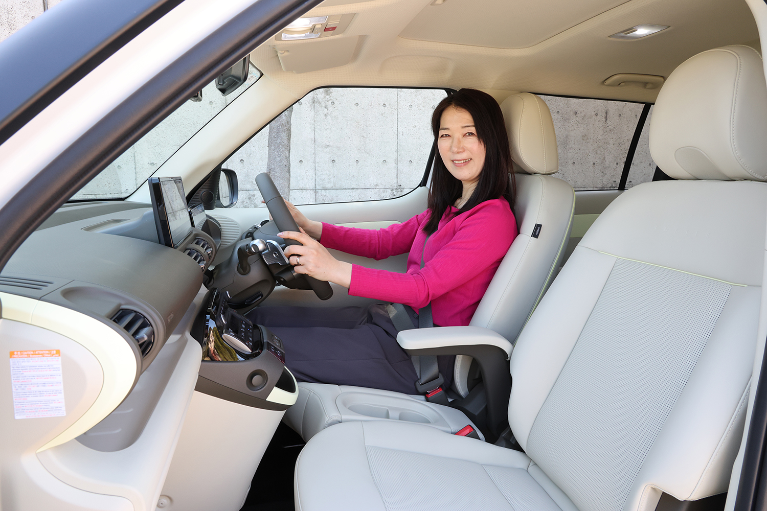 ヒョンデ・インスターの運転席に座るまるも亜希子さん