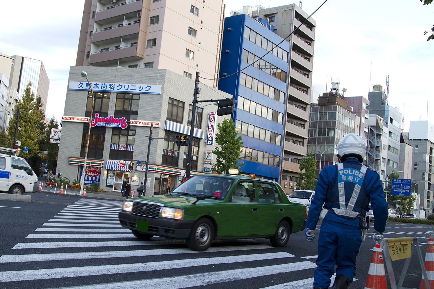 警官の前を通り抜けるタクシー