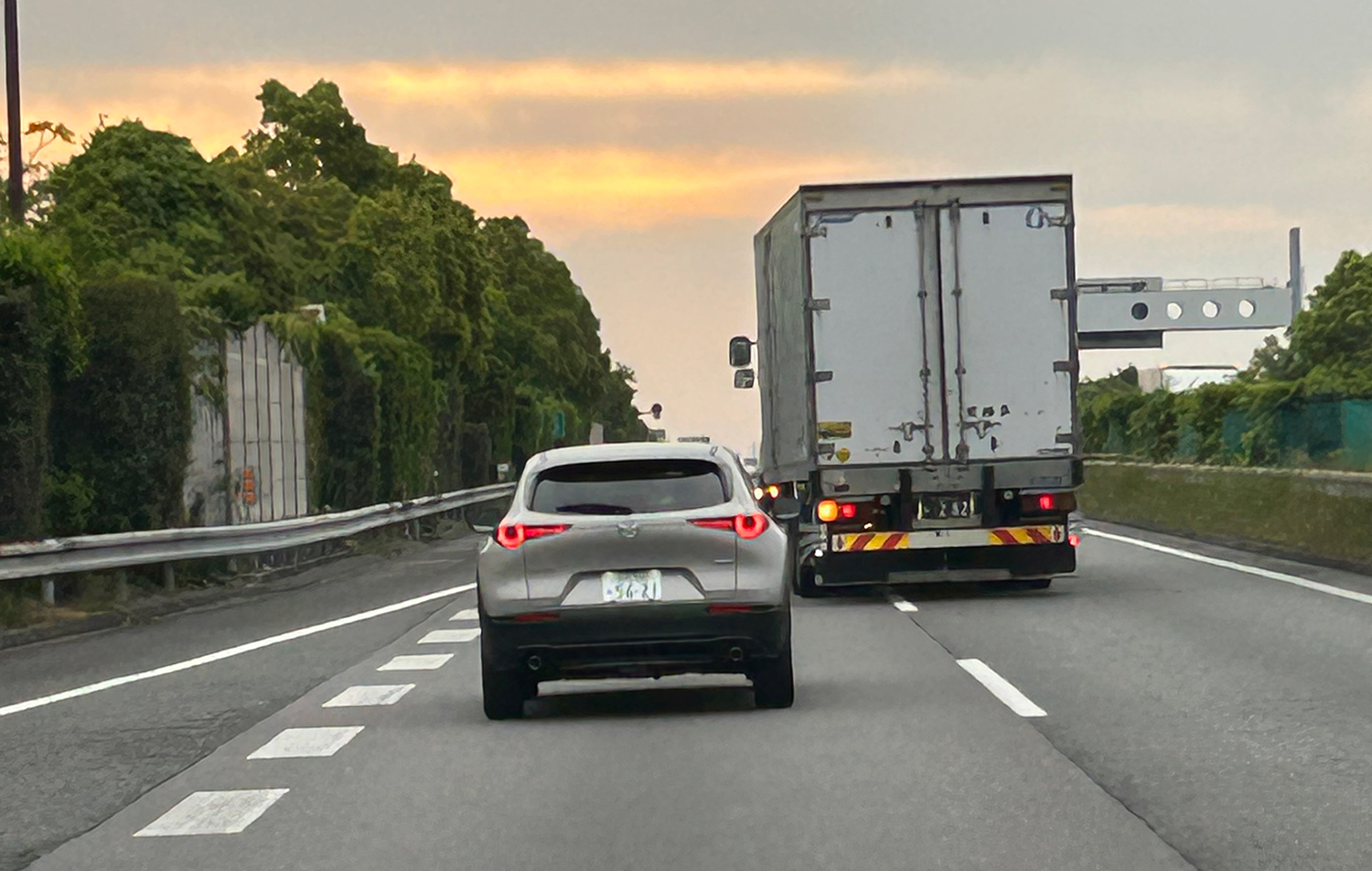 高速道路を走る一般車とトラックのイメージ