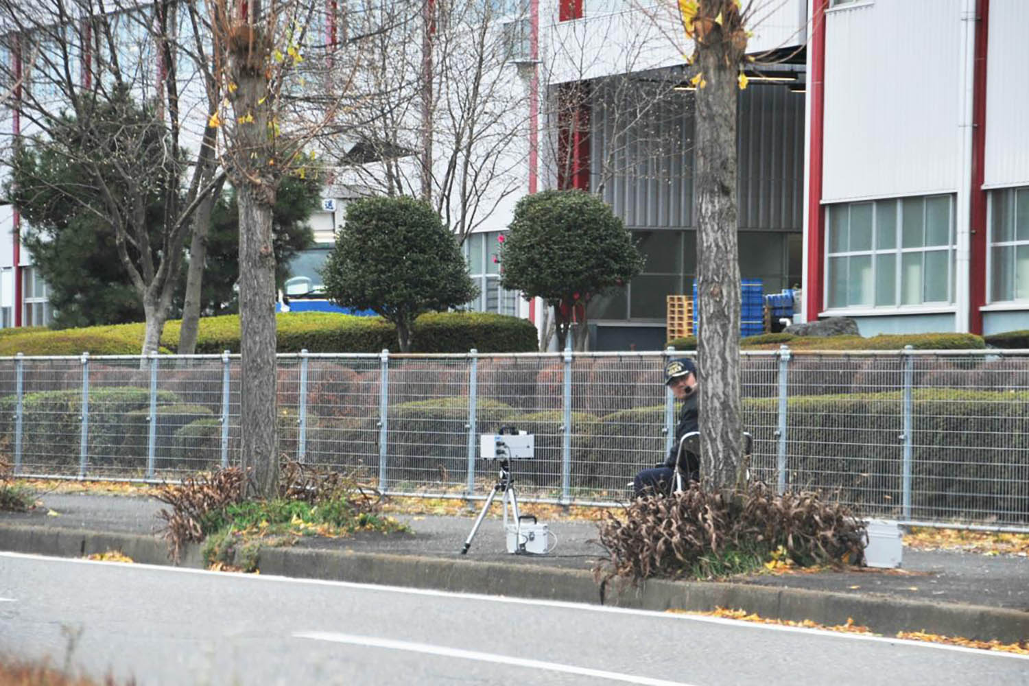 物陰に隠れてスピード違反を取り締まっている警察官
