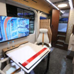 まるで事務所のような空間がバスの車内ってマジか！　BYDのEVバス「J6リビングカー」なら走っていても止まっていても環境に優しくくつろげる【ジャパンモビリティショー2025】
