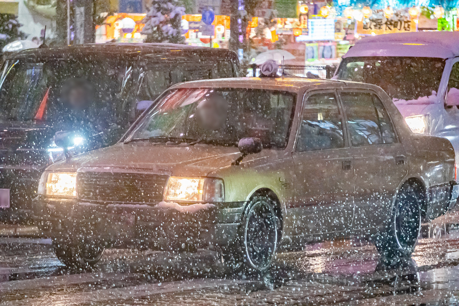 雪のなかを走るタクシー