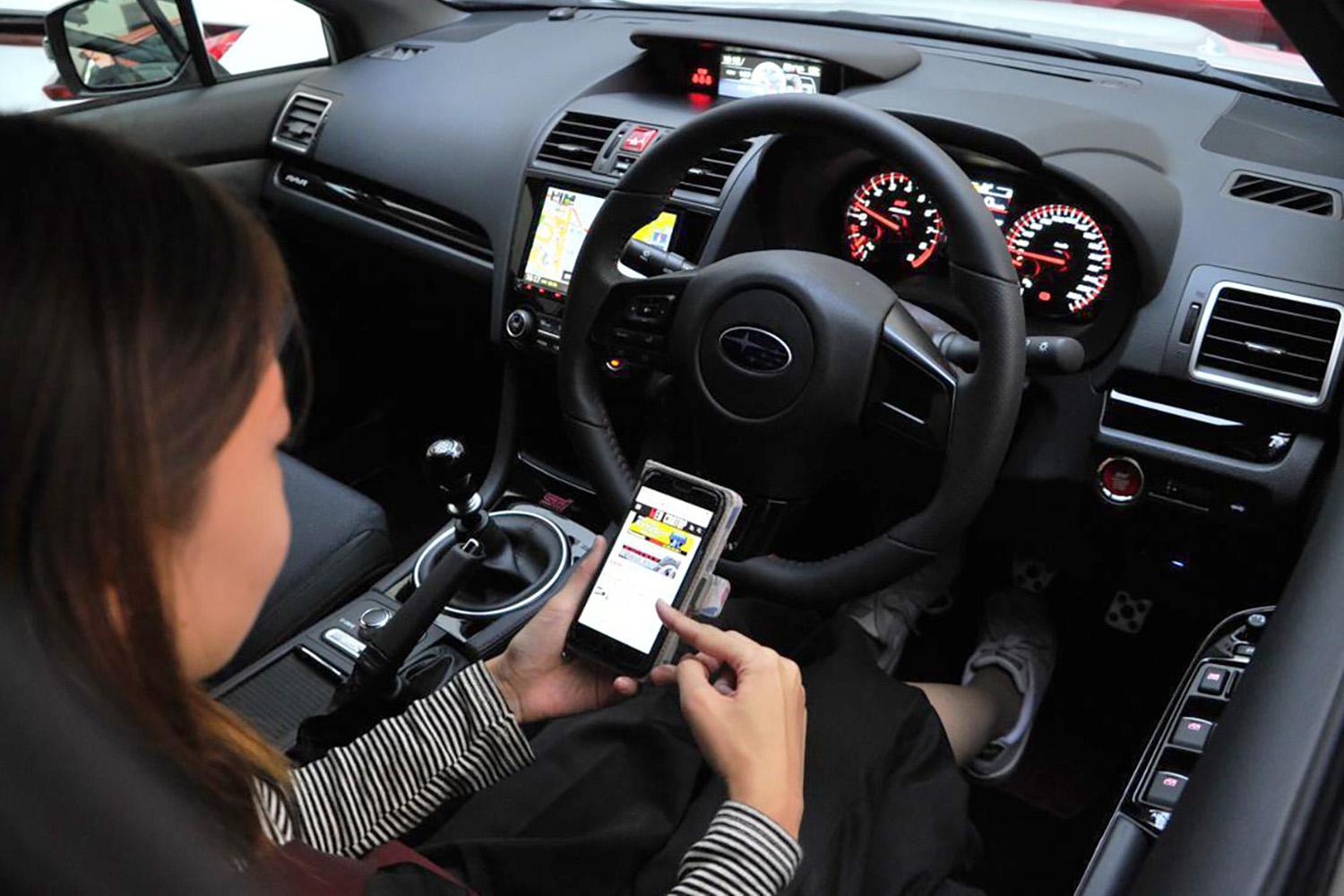 運転中にスマホ操作をするイメージ