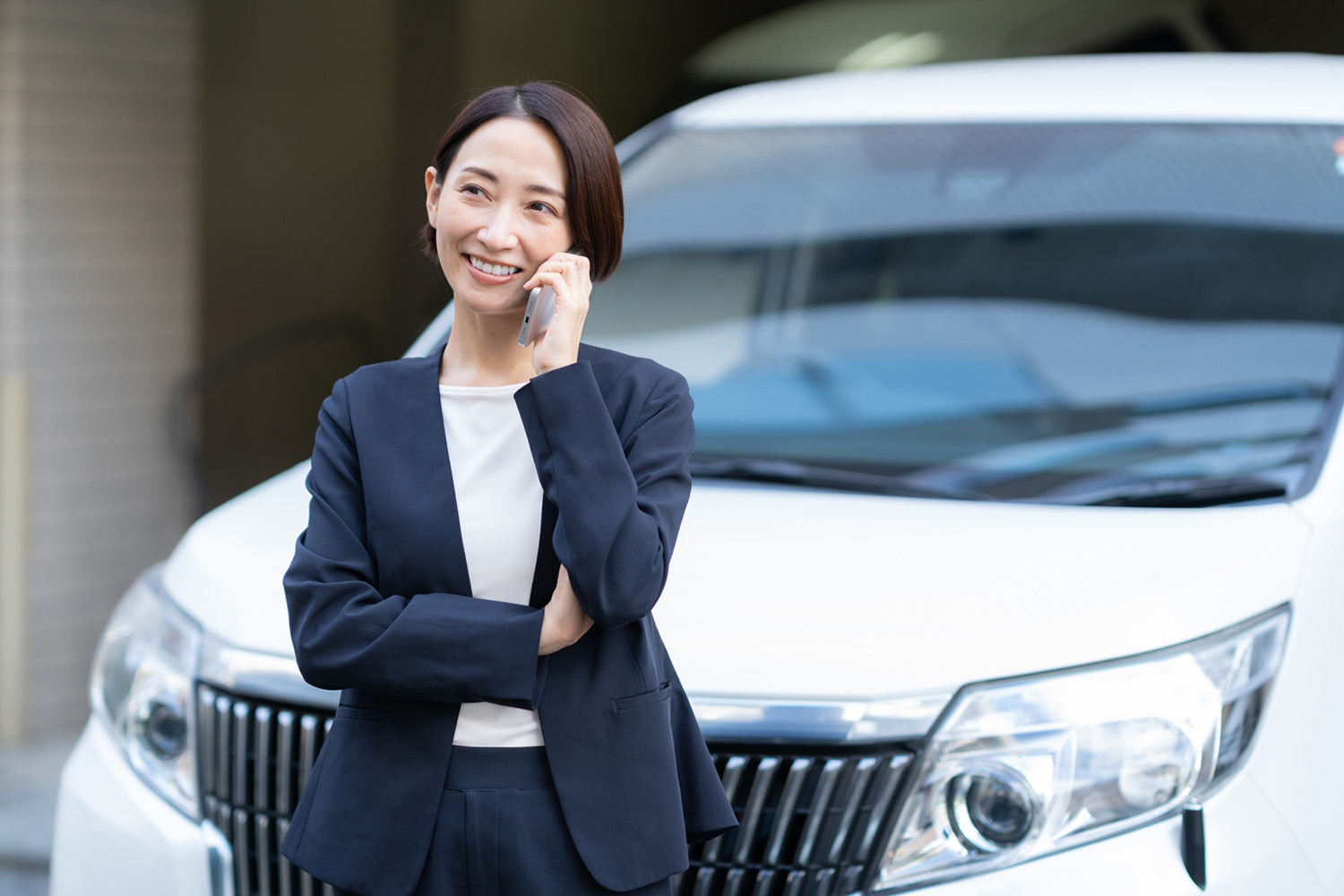 クルマから降りて通話するイメージ