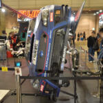 【画像】クルマが横倒しでマフラーまる見え！　フジツボブースの展示は技術力もまる見えだった【東京オートサロン2026】 〜 画像1