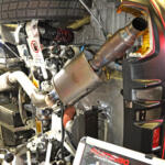 【画像】クルマが横倒しでマフラーまる見え！　フジツボブースの展示は技術力もまる見えだった【東京オートサロン2026】 〜 画像4