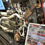 【画像】クルマが横倒しでマフラーまる見え！　フジツボブースの展示は技術力もまる見えだった【東京オートサロン2026】 〜 画像5