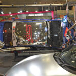 クルマが横倒しでマフラーまる見え！　フジツボブースの展示は技術力もまる見えだった【東京オートサロン2026】