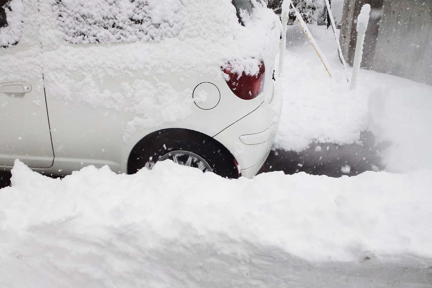 マフラーが雪に埋まったクルマのイメージ